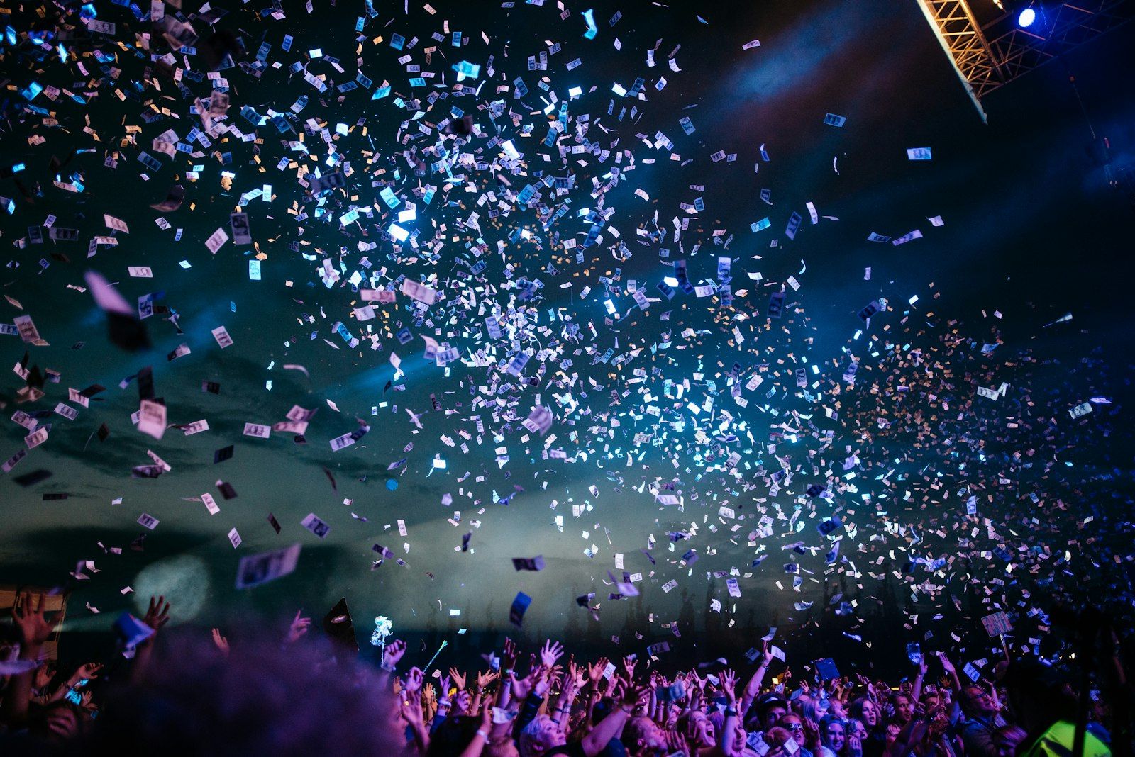 Uczestnicy wydarzenia pod deszczem confetti przed sceną